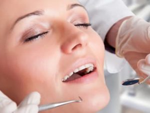 A woman relaxes during dental treatment after receiving conscious sedation.
